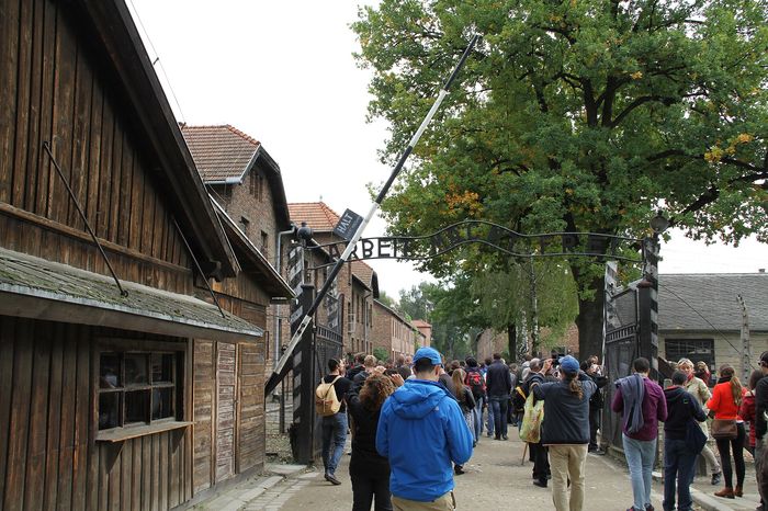 The gate of Auschwitz I. A tour with an educator covers both camps and takes about three and a half hours; the transfer between Auschwitz I and Birkenau is included in the price.
