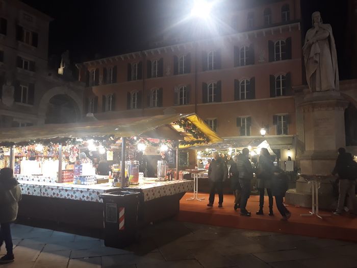 A stall with mulled wine and decorations in front of the Dante statue on Piazza dei Signori.