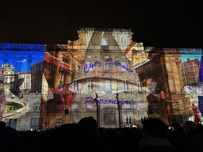 The 2025 Fête des Lumières on Place des Terreaux: a projection on the façade with Lyon's food as its theme.