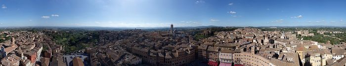 The Torre del Mangia and the Palazzo Pubblico close the lower side of the square, and the Palio course runs right past them.