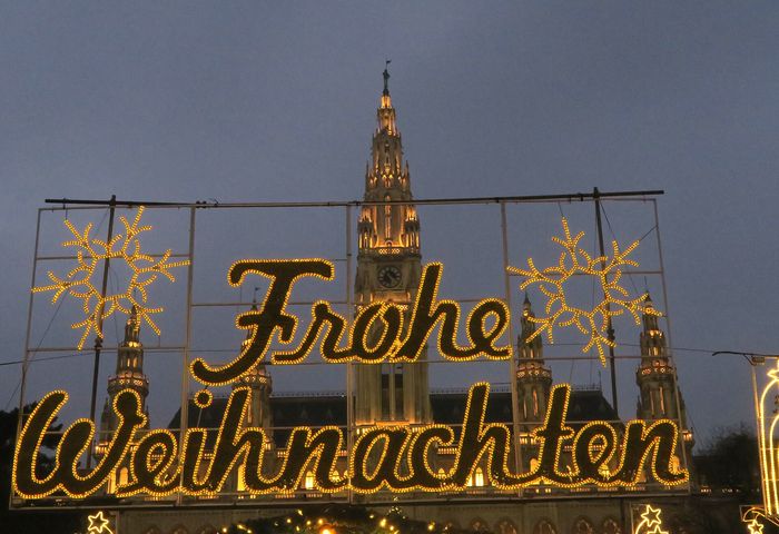 The lit "Frohe Weihnachten" greeting in front of the Rathaus tower.
